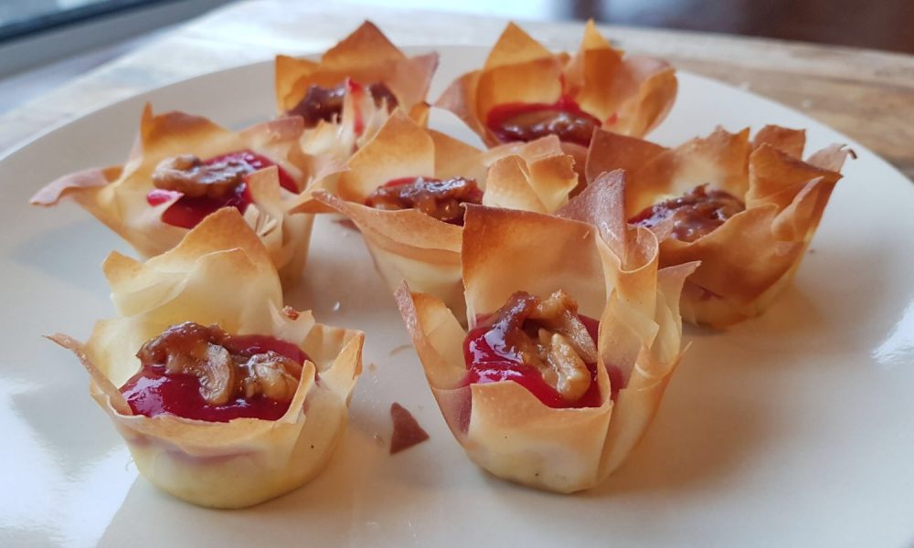 Ein eleganter Snack mit schmelzendem Brie, süßer Himbeersauce und knusprigen Walnüssen