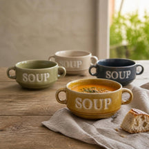 Soup soepkommen in oker, groen, crème en blauw op een houten tafel