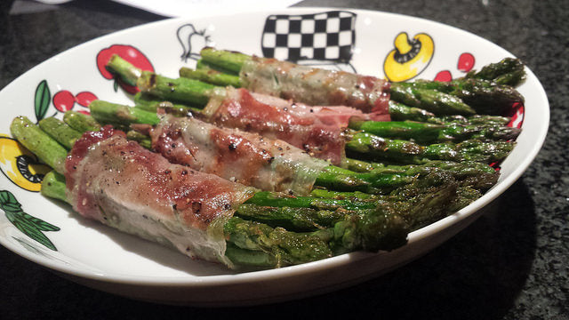 Knusprige Schinkenröllchen vom Grill mit grünen Spargelspitzen