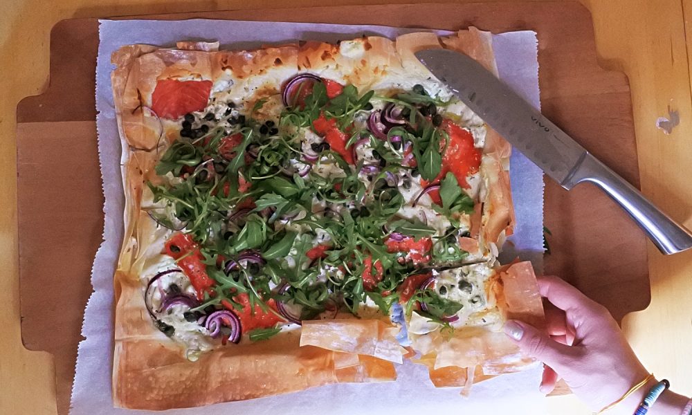 Knusprige Blechpizza mit Lachs, Kräuterfrischkäse und frischer Rucola