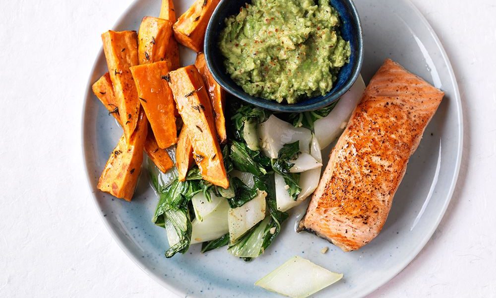 Saftiger Lachs mit cremigem Avocadodip, knackigem Pak Choi und würzigen Süßkartoffelspalten
