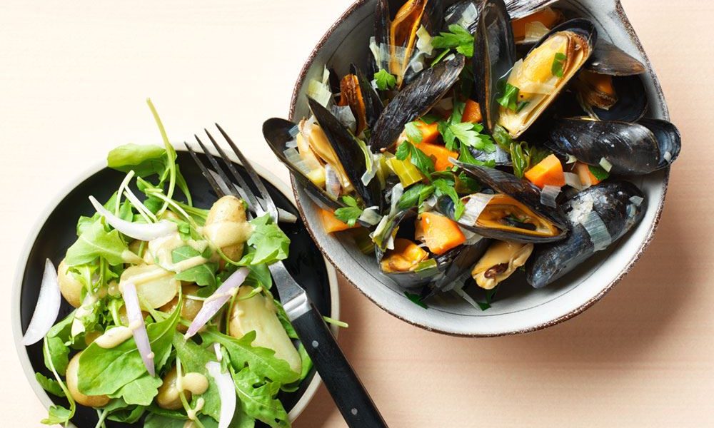 Frische Muscheln mit Gemüse und ein frischer Salat aus kleinen Kartoffeln und Rucola
